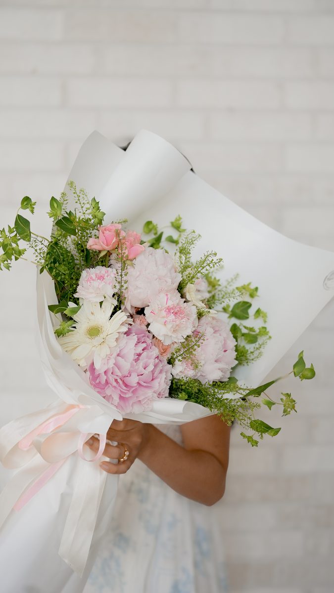 Garden Whisper bouquet — soft pink peonies, seasonal blooms, and airy greenery arranged in a natural garden style