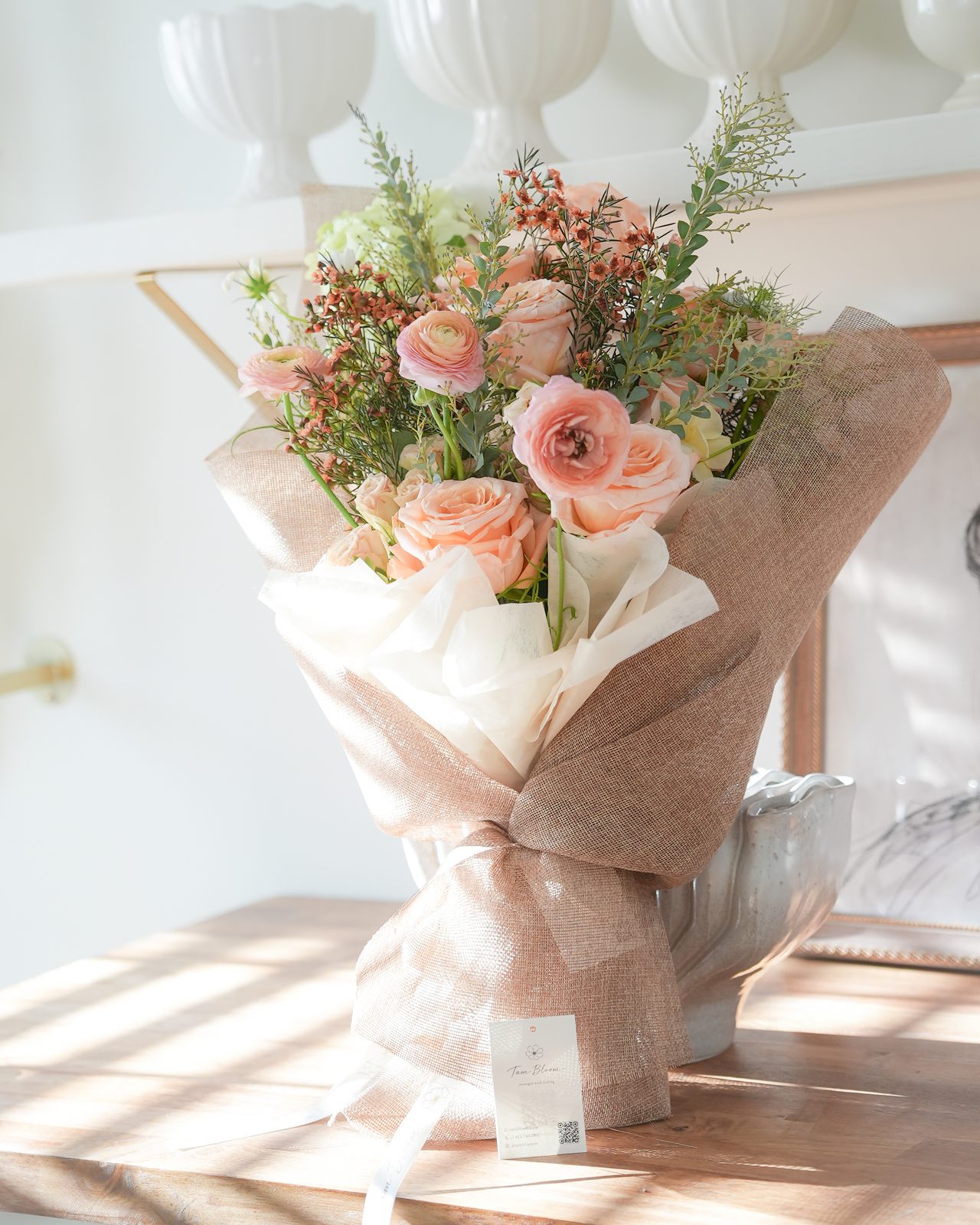 The Garden Gather — a seasonal hand-tied bouquet of peach roses, ranunculus, hydrangea, and airy foliage in premium floral wrapping